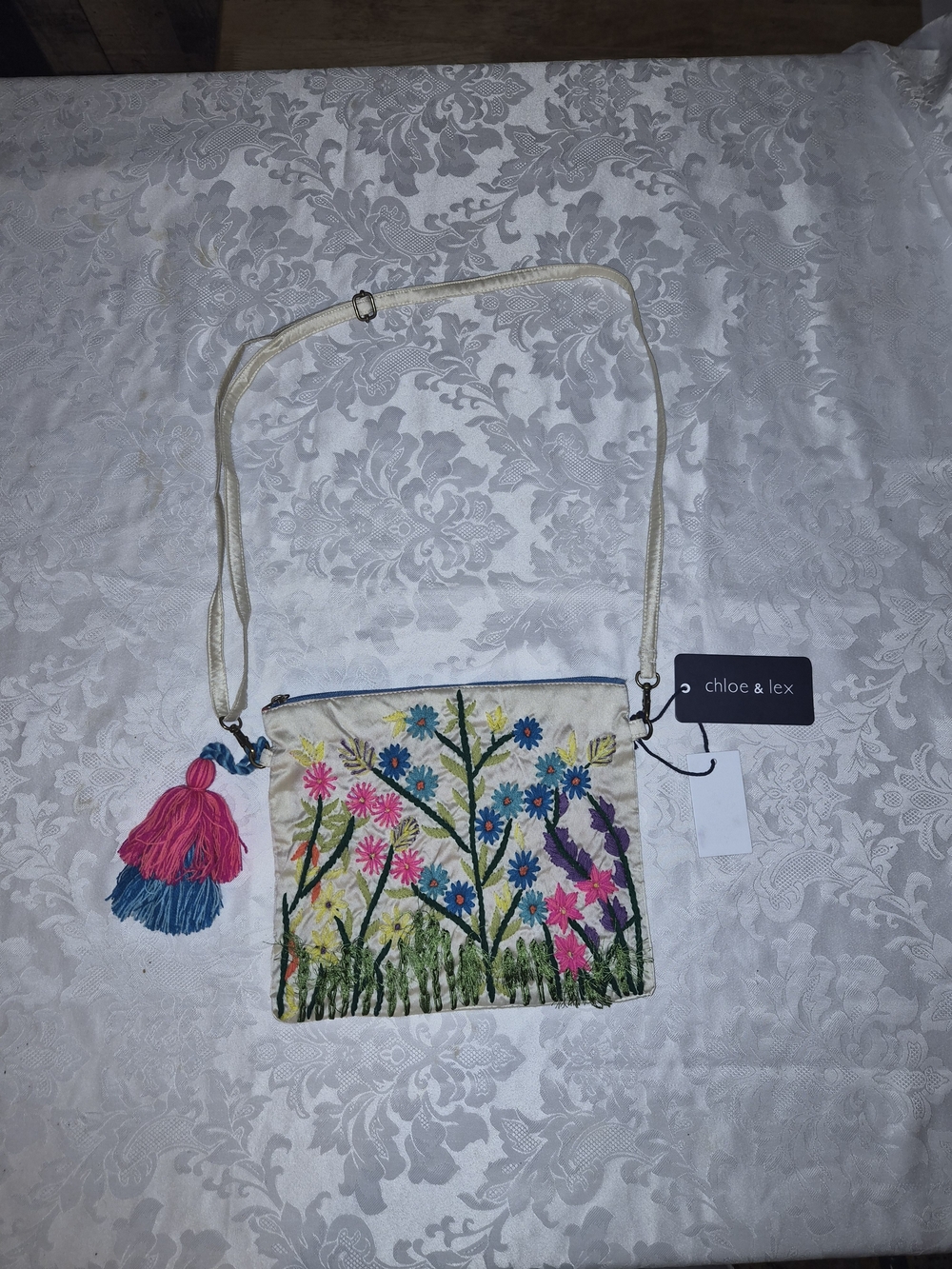 Chloe & Lex Cream Embroidered Floral Crossbody with Pink & Blue Tassel